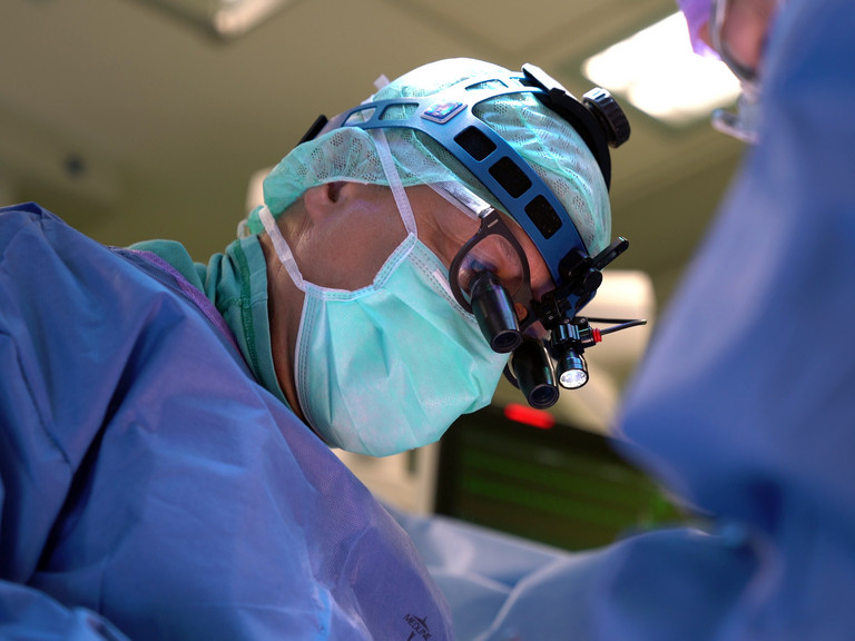 [Translate to Russisch:] Arzt mit Operationsbrille während einer Operation in der Klinik für Kardiochirurgie im Albertinen Krankenhaus/Albertinen International in Hamburg 